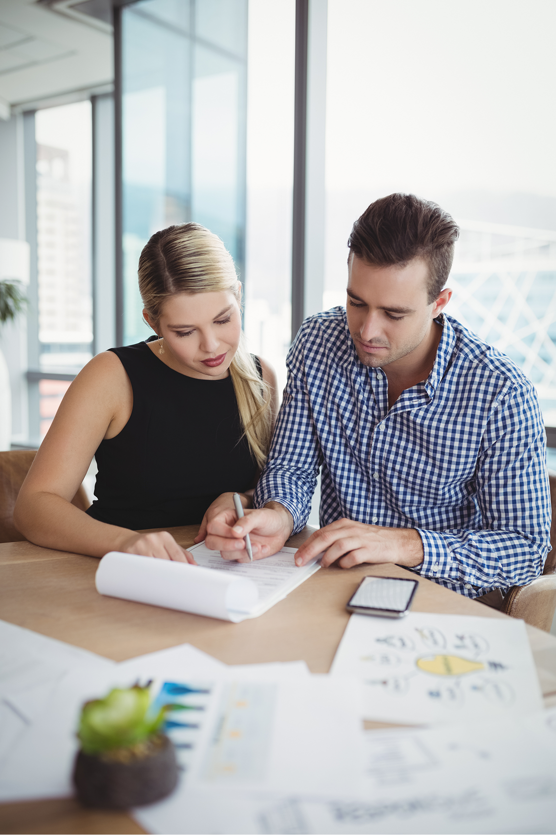 executives-discussing-over-paper-at-desk