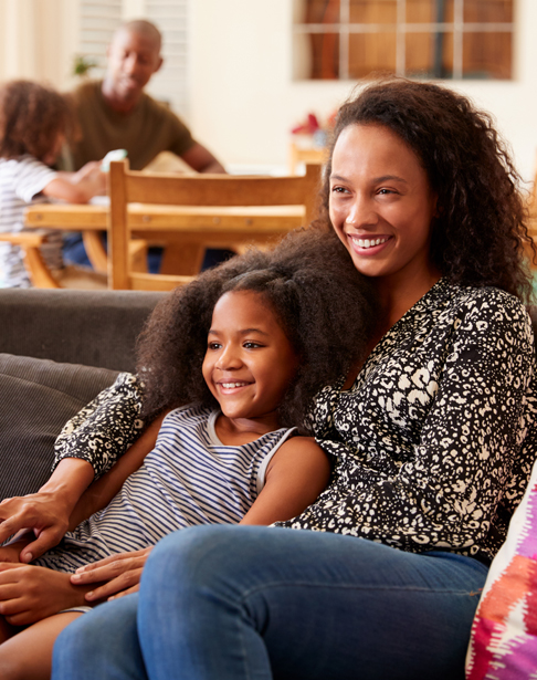 mother-and-daughter-sitting-on-sofa-at-home-watchi-2024-10-19-11-57-34-utc2
