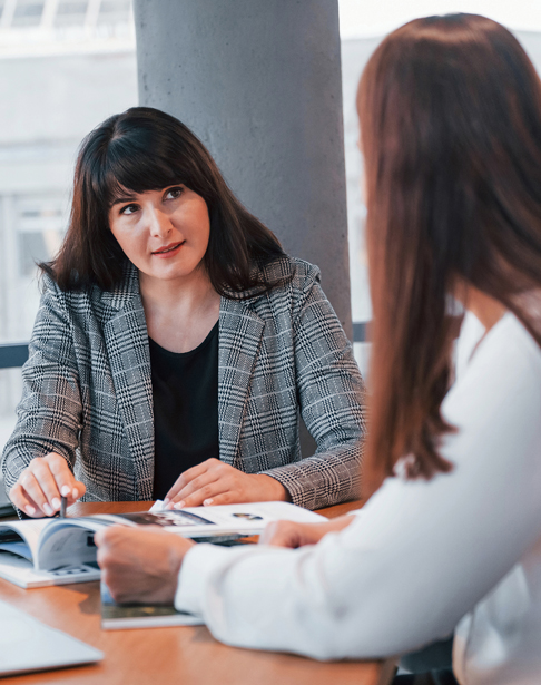 sitting-by-the-table-two-women-in-formal-clothes-raleigh-divorce-lawyers-ellis-family-law