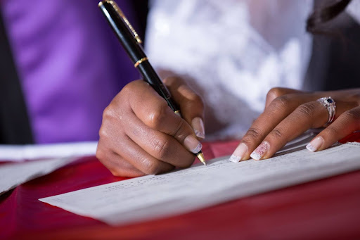 woman-signing-marriage-agreement-with-husband